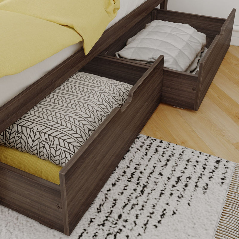 Under-bed storage drawers in dark wood platform bed holding pillows and blankets — space-saving bedroom storage solution on hardwood floor with patterned rug