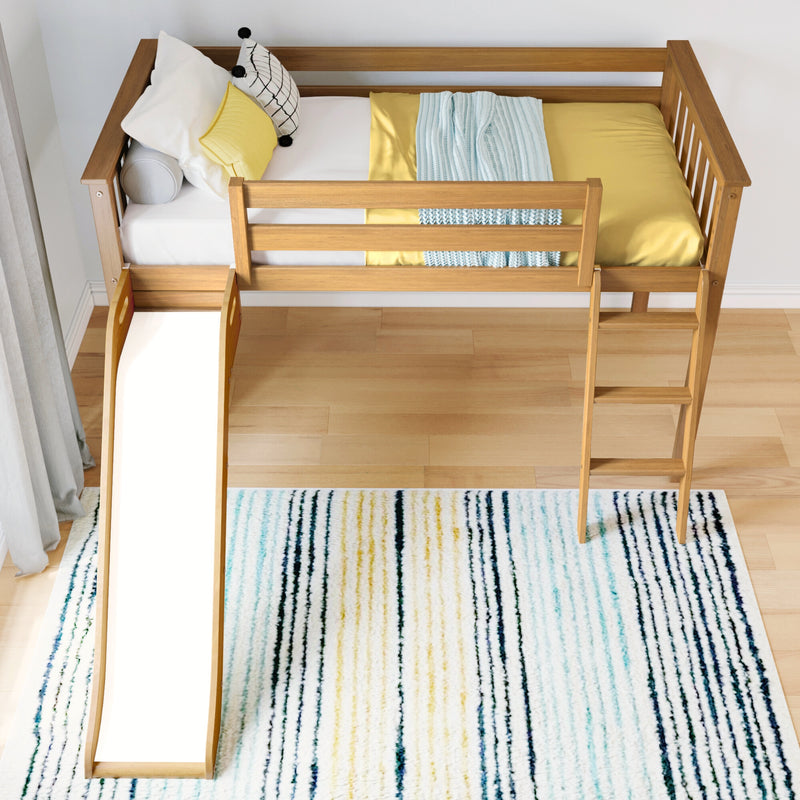 Kids loft bed with slide and ladder, natural wood frame, yellow bedding, decorative pillows and light blue knit throw on hardwood floor with striped rug