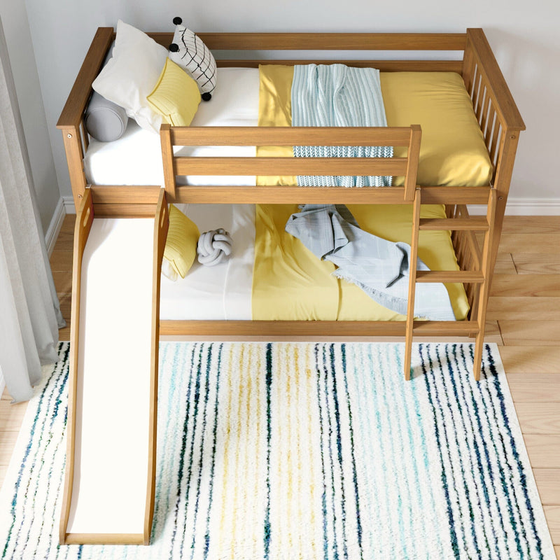 Aerial view of a wooden kids bunk bed with slide, yellow bedding, blue knit throw and striped area rug in a modern children's bedroom
