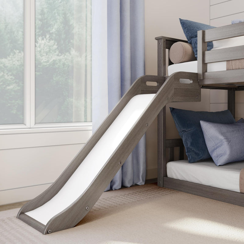 Kids bunk bed with slide in modern grey wood, navy pillows, white mattress, soft curtains and large window in a bright children's bedroom