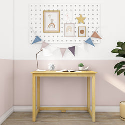 Minimalist home office setup with wooden desk, open book, table lamp, and wall art on light pastel walls.