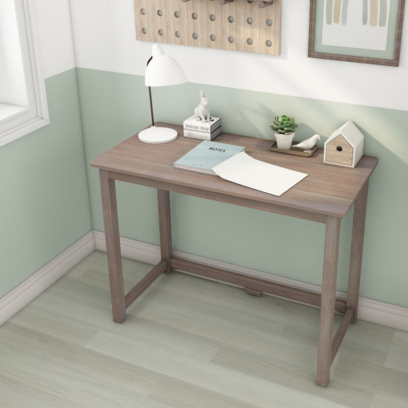 Home office desk with white lamp, wooden desk, mint green half-wall, notebook, succulent, decorative birdhouse and ceramic rabbit