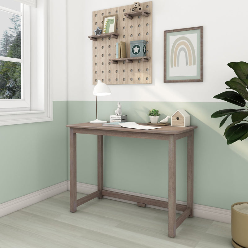 Kids study nook and nursery wall decor: wooden desk with white lamp, succulent, birdhouse, modular pegboard shelves with toys and books on a pastel green wall with framed rainbow art