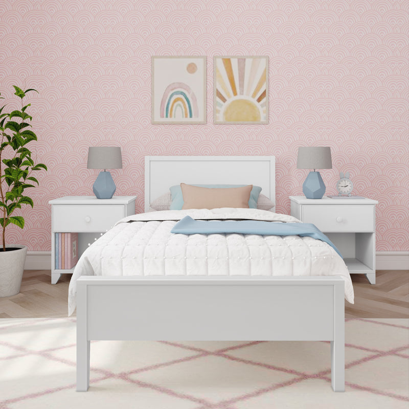 Pastel pink nursery bedroom with scalloped wallpaper, white bed frame, rainbow and sun wall art, blue bedside lamps and cozy bedding
