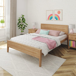 Modern bedroom with wooden bed frame, white bedding, pink and turquoise pillows, and decorative plants.