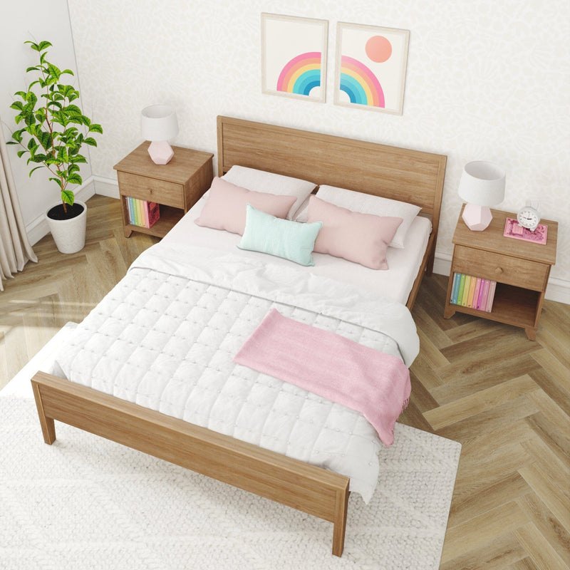 Scandinavian bedroom interior with wooden bed frame, pastel pink and mint bedding, matching wood nightstands with lamps, potted plant and colorful rainbow wall art