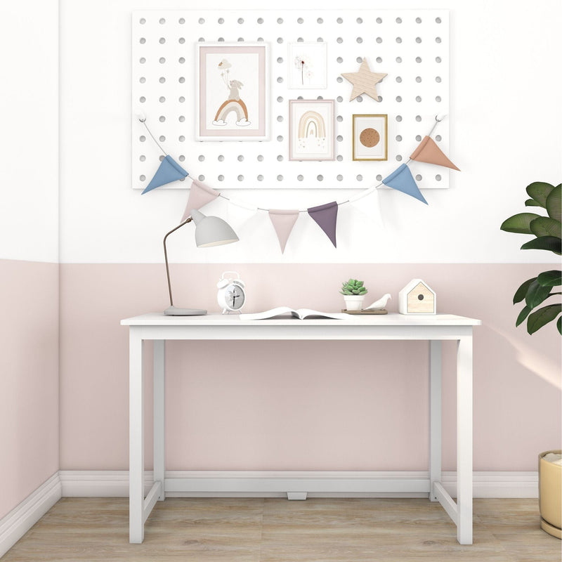 Minimalist white kids desk in a pastel pink nursery with pegboard gallery, colorful bunting, task lamp, succulent and wooden floor, children's study nook decor