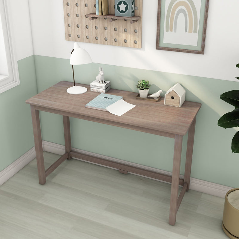 Minimalist Scandinavian children's desk with light wood tabletop, white desk lamp, succulent planter, birdhouse and pegboard storage against a mint green accent wall with rainbow wall art