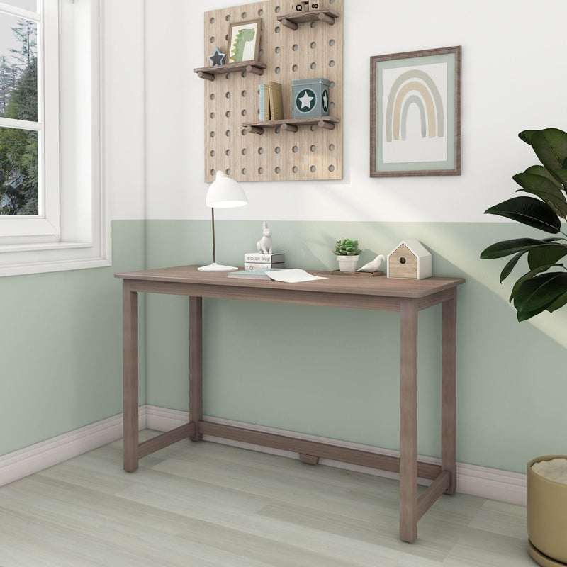 Minimalist wooden console desk in a bright small home office with mint-green half-painted wall, white desk lamp, potted plant, and pegboard shelves