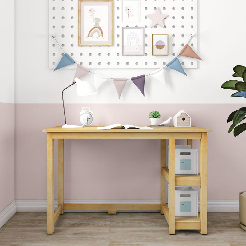 Kids' wooden study desk with white desk lamp, alarm clock, open book, succulent and storage boxes against pink half-wall with pegboard gallery and pastel bunting flags