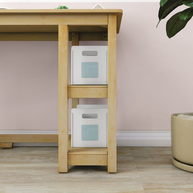 Under-desk wooden shelving with two white storage boxes and a potted plant against a pastel pink wall, modern home office storage solution