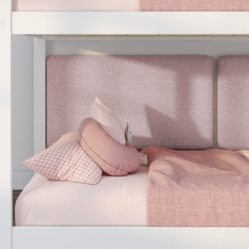 Pink twin bed with white wooden frame, gingham and blush pillows, textured headboard panels and soft pink bedding in a kids' bedroom