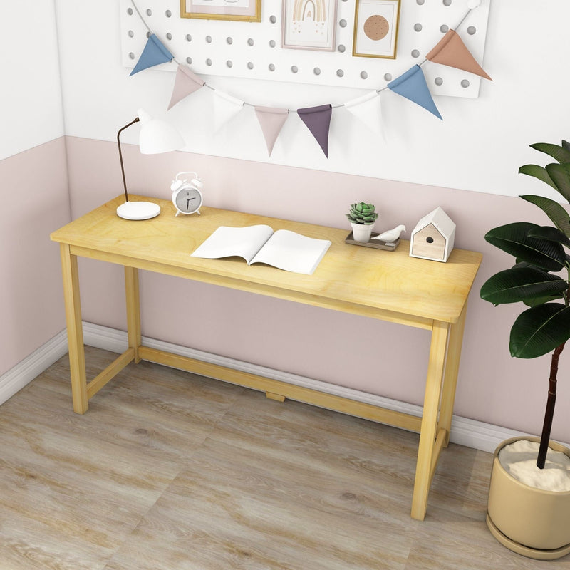Light wood study desk in pastel pink home office with lamp, alarm clock, open book, succulent, bunting and potted plant