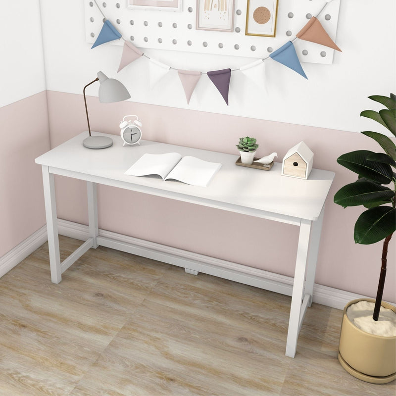 Modern white minimalist writing desk in pink and white kids' room with lamp, alarm clock, open notebook, succulent, wooden birdhouse, pennant banner and potted plant on light wood floor