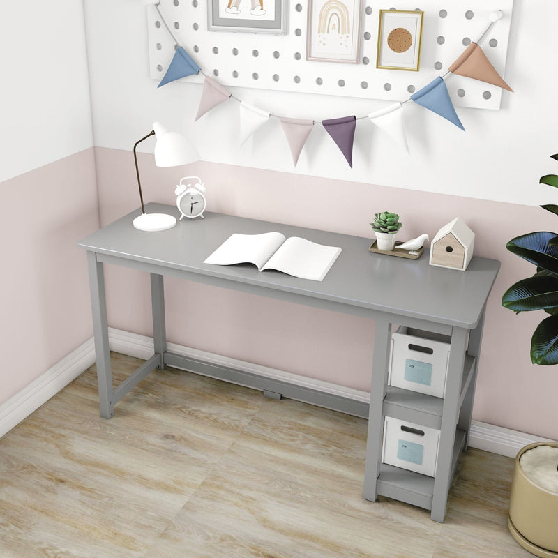 Small gray kids study desk with built-in storage shelves, lamp, open book and succulent in pastel pink nursery with bunting garland and wood floor
