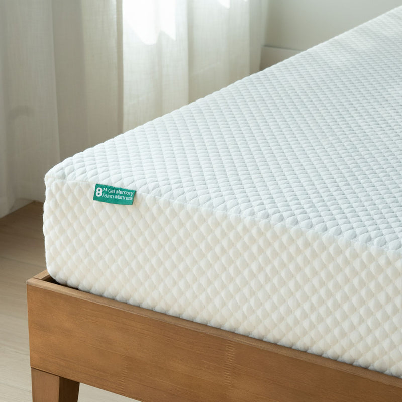 Mattress with a brand label on a wooden bed frame against a neutral background