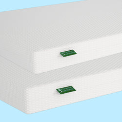 Memory foam mattresses with textured white covers on a light blue background.