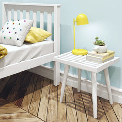 Modern bedroom interior with white bed, wooden nightstand, yellow lamp, and potted succulent for cozy decor.