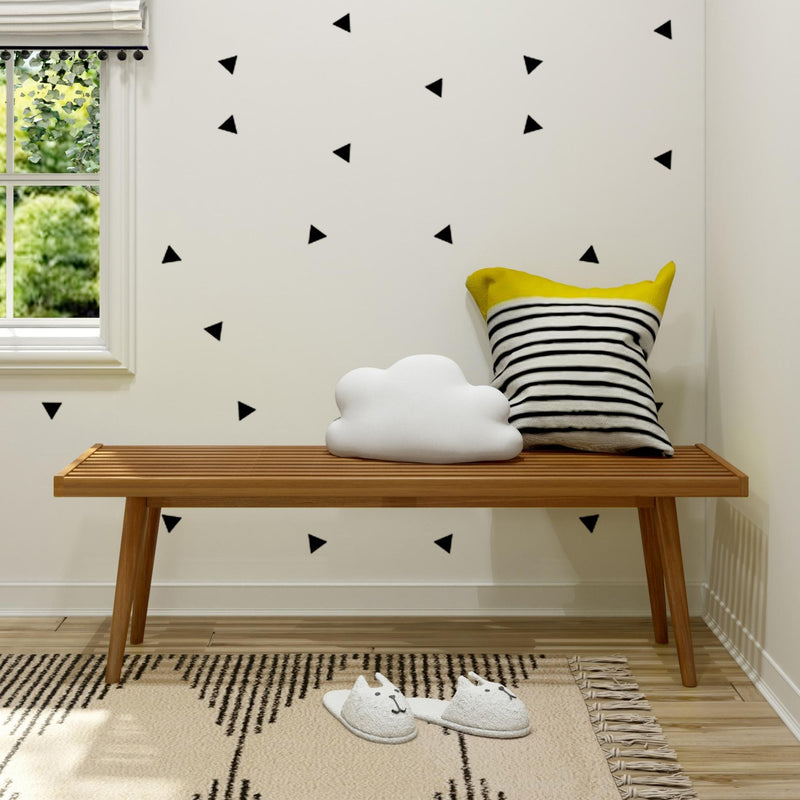 Scandinavian kids room decor: wooden bench with cloud pillow and yellow striped cushion, black triangle wall decals, window greenery and cat slippers