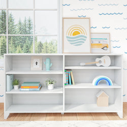 Modern white bookshelf with plants, books, and decorative items in a bright room with nature view.