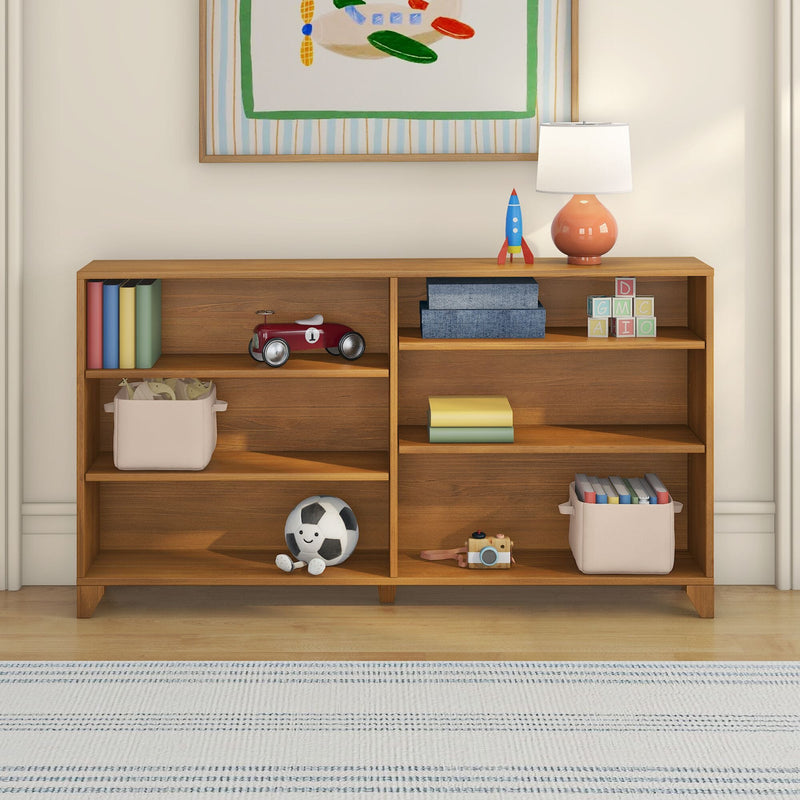 Wooden kids bookshelf and toy storage in nursery with table lamp, blue toy rocket, red ride-on car, alphabet blocks, books and plush soccer ball