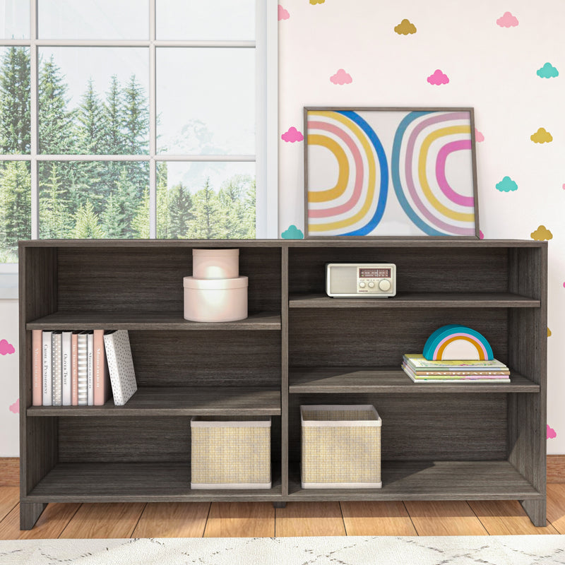 Wooden cubby bookshelf in a kids' room with rainbow wall art, pastel cloud wallpaper, stacked books, woven storage baskets and vintage radio