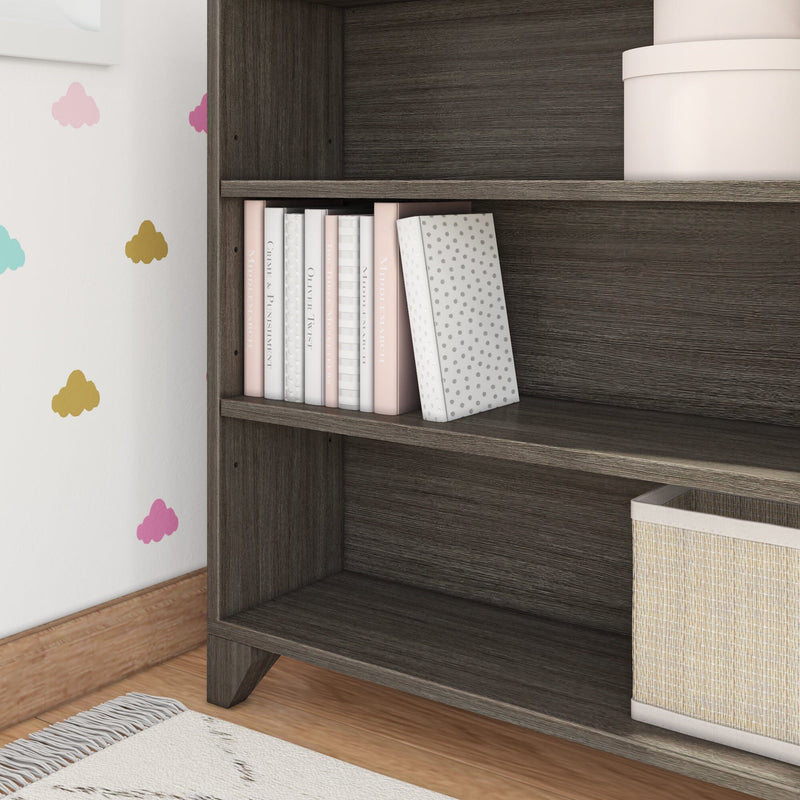 Children's room bookshelf with colorful cloud decals and neatly organized books and storage box.
