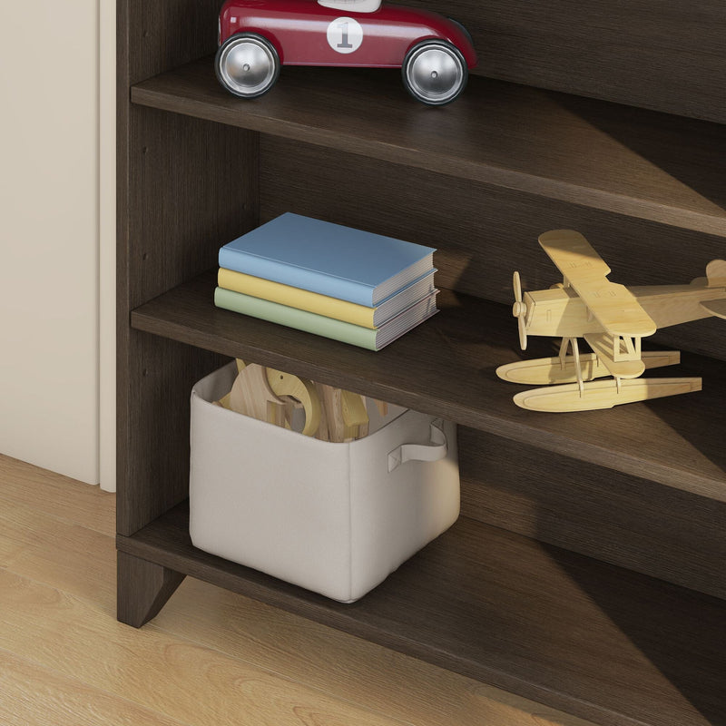 Dark wood nursery shelves with wooden toy biplanes, red toy car, stacked pastel children's books and fabric storage bin of toys