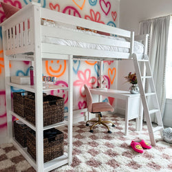 Loft bed with study desk in colorful teen bedroom with graffiti art wall and cozy decor.