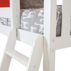 White wooden ladder of a children's bunk bed with giraffe-patterned bedding.