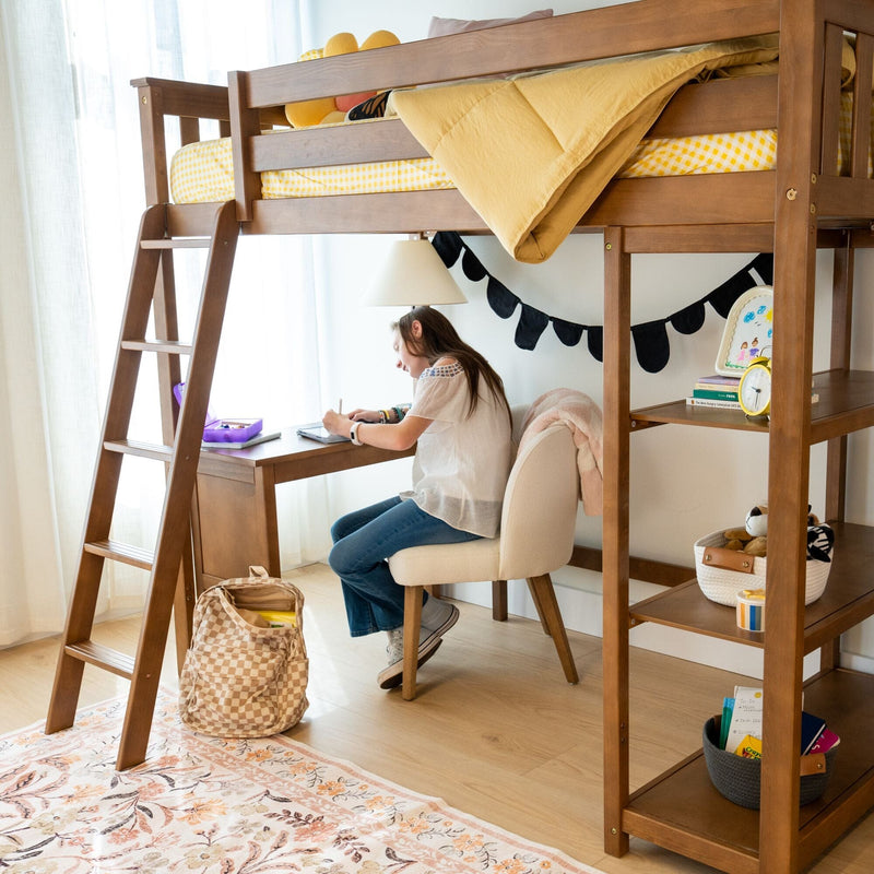 Child studying at a wooden loft bed with built-in desk and ladder, yellow bedding and organized kids bedroom study nook
