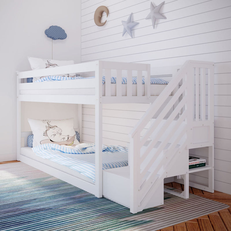 White wooden twin-over-twin bunk bed with built-in staircase storage, blue striped bedding and unicorn pillow in bright shiplap kids' bedroom with star and moon wall decor and striped rug