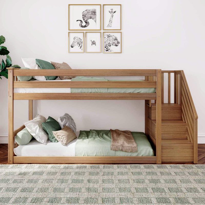 Natural wood twin-over-twin bunk bed with staircase storage, green bedding and animal wall art in a modern kids bedroom with patterned rug