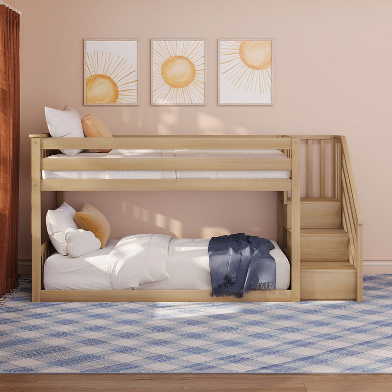 Light wooden bunk bed with stairs in blush-pink kids' room, sun wall art, cloud cushions and blue plaid rug
