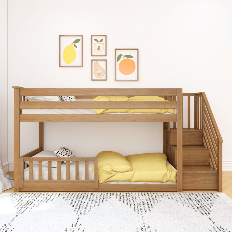 Wooden kids bunk bed with stairs and built-in storage, yellow bedding and fruit wall art in a modern nursery