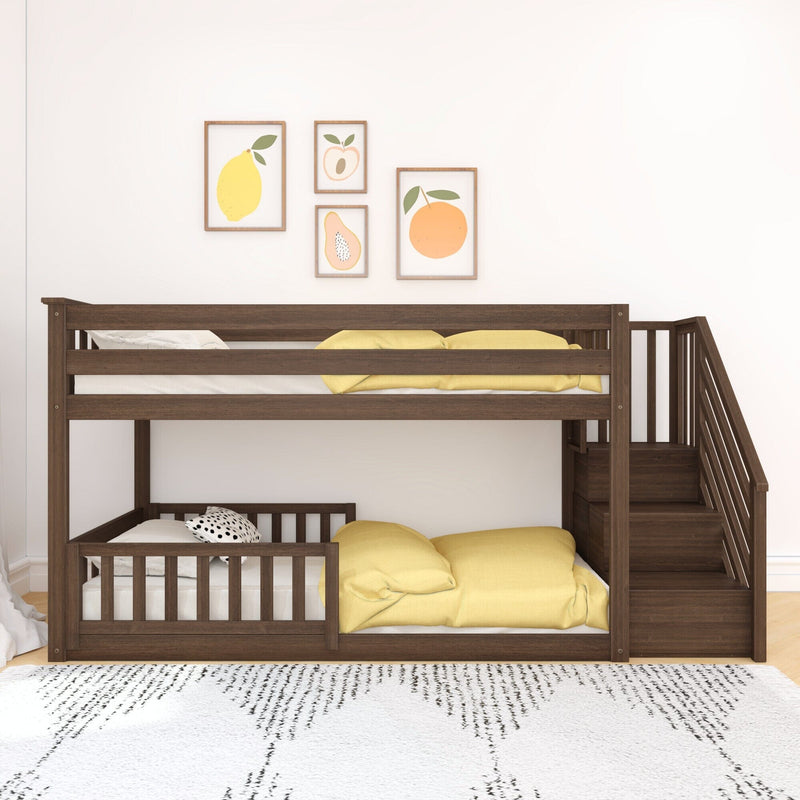 Dark wood bunk bed with yellow bedding and staircase storage, patterned white rug and framed fruit prints in a modern kids' room nursery