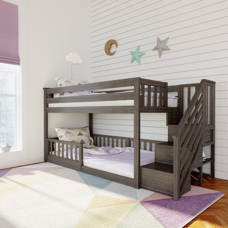 Gray wooden twin-over-full bunk bed with staircase and storage in modern kids bedroom, pastel bedding and pillows, shiplap wall with moon and star decor, purple roman shade