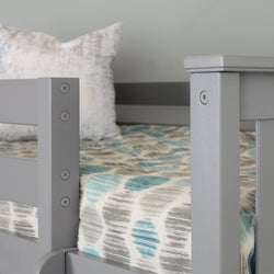 Gray wooden bed frame with blue patterned bedding and decorative pillow.