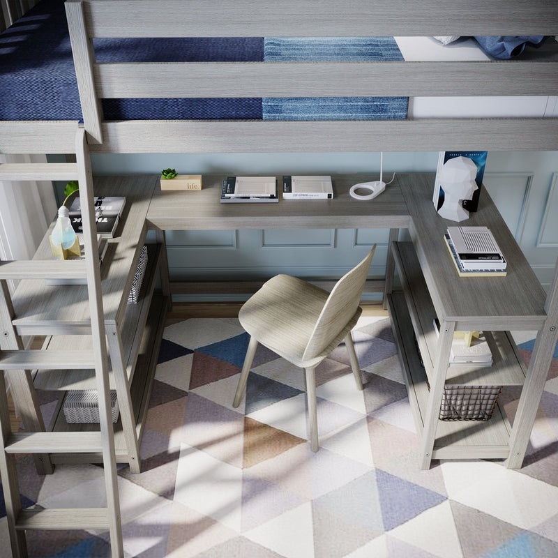 Space-saving gray wood loft bed with integrated L-shaped study desk, ladder, shelving and chair over geometric rug in a bright kids' bedroom