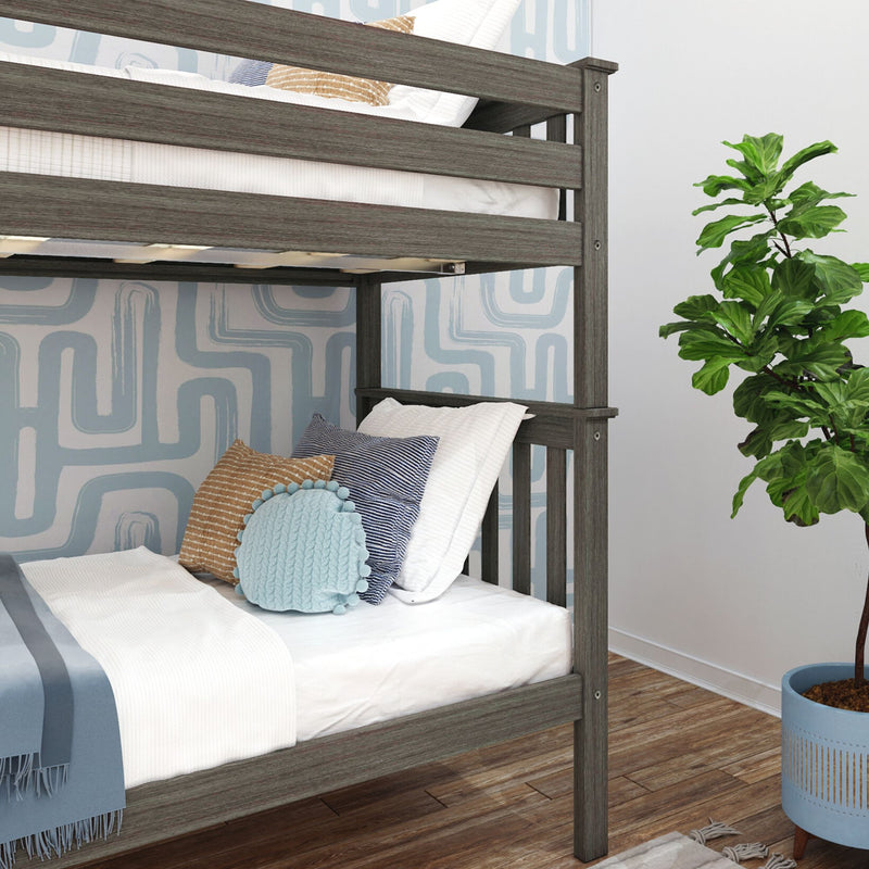 Gray wooden bunk bed in modern kids' bedroom with blue and tan pillows, geometric wallpaper, and fiddle leaf fig plant