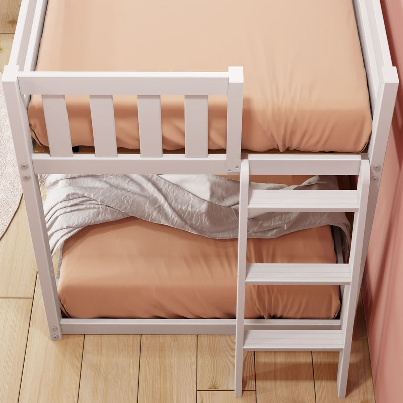 Top-down view of white wooden bunk bed with ladder, peach fitted sheets and beige blanket on lower bunk on hardwood floor in children's bedroom