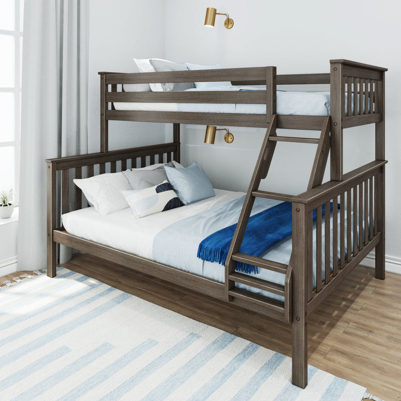 Grey oak twin-over-full wooden bunk bed with ladder, blue bedding, pillows and brass wall sconces in bright kids' bedroom