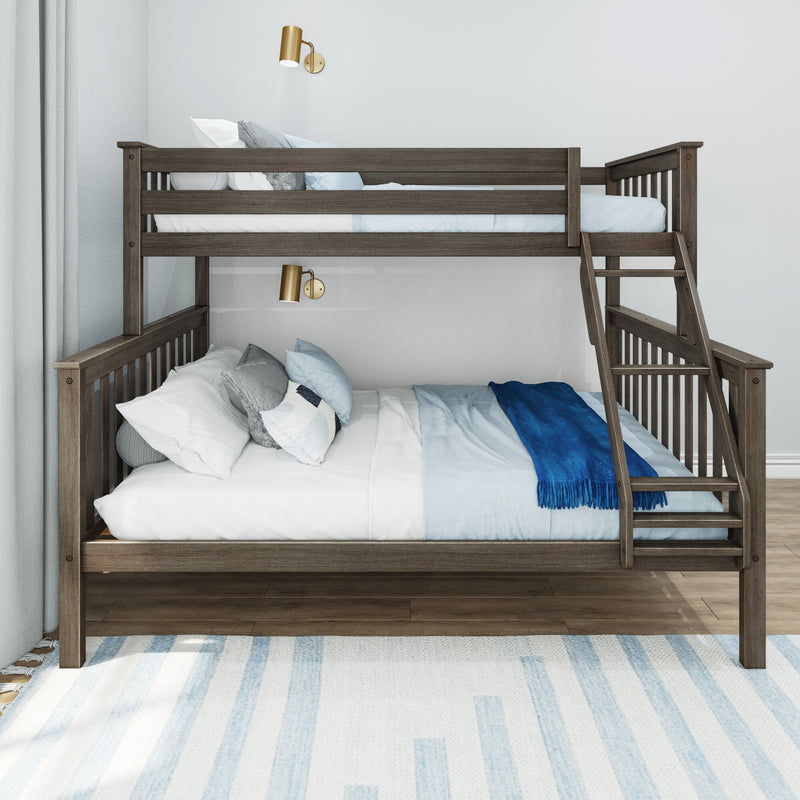 Dark wood twin-over-full bunk bed with ladder, blue and white bedding and pillows, brass wall sconces and light grey curtains in a modern kids bedroom