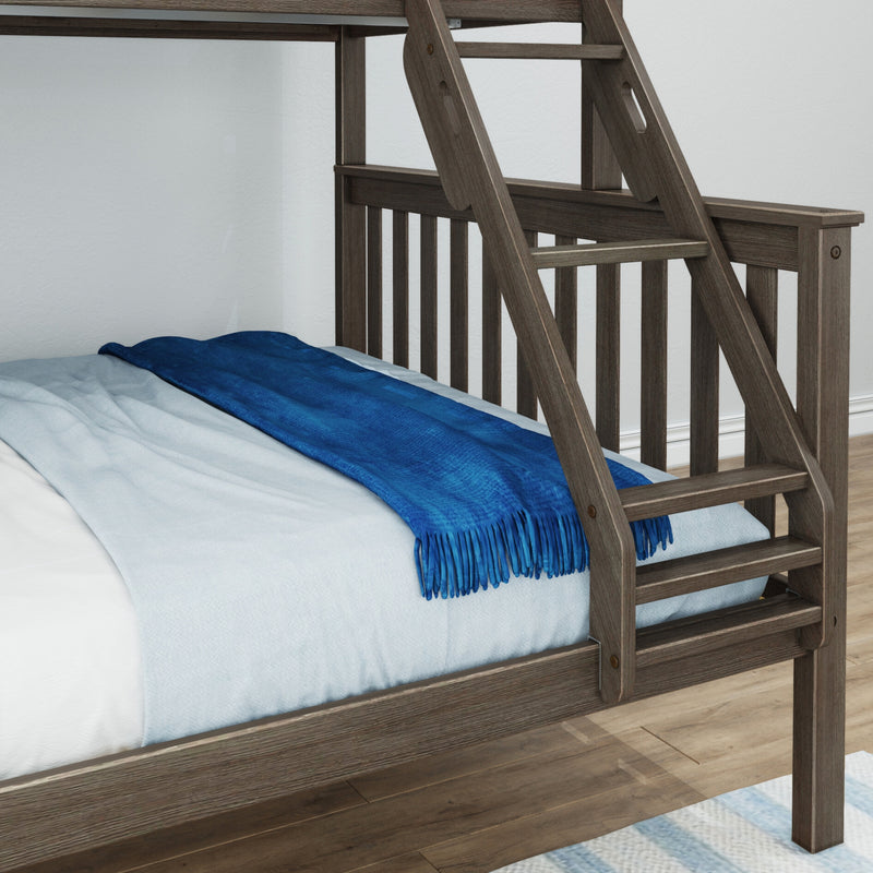 Close-up of rustic gray-brown solid wood bunk bed ladder and guardrail with blue blanket on lower twin mattress over hardwood floor