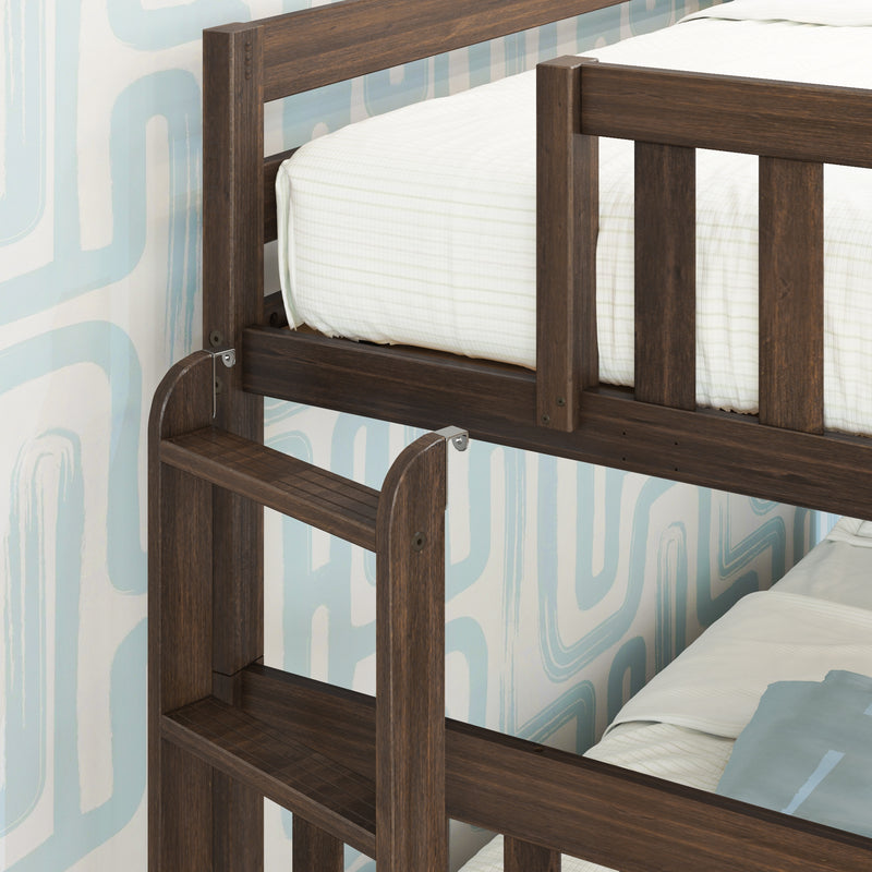 Close-up of dark walnut solid wood bunk bed ladder and safety guardrail with white striped mattress and blue geometric wallpaper in kids' bedroom