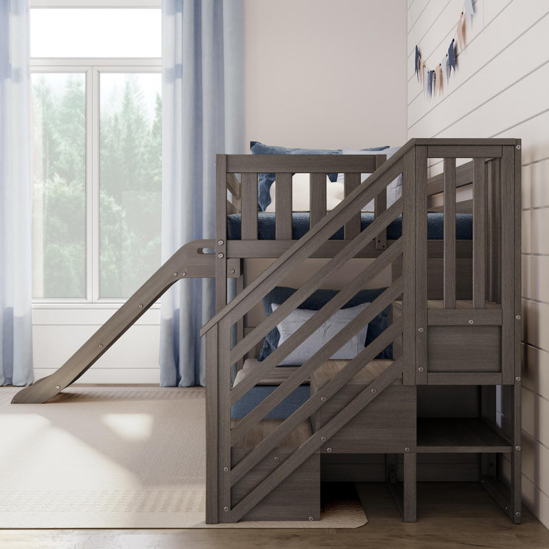 Modern gray wooden loft bunk bed with slide and built-in storage stairs in a bright children's bedroom with blue pillows, shiplap wall and window with light blue curtains
