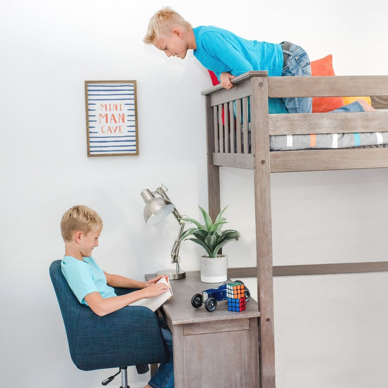 Wooden loft bed with built-in desk in modern boys' bedroom — one boy reading at desk with toy car and Rubik's Cube, another leaning from top bunk under a framed "Mini Man Cave" sign