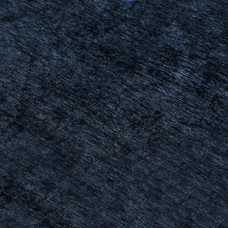Close-up navy blue textured velvet fabric with soft pile and subtle linear striations, luxury upholstery or rug background
