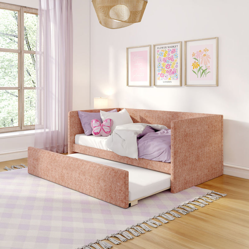 Pastel pink girls' bedroom with blush upholstered trundle daybed, lavender bedding, butterfly pillow, floral wall art and sheer curtains