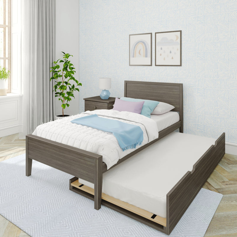 Modern kids bedroom with dark wood trundle bed, white and pastel bedding and blue throw, bedside lamp, framed rainbow/cloud prints and potted plant by window